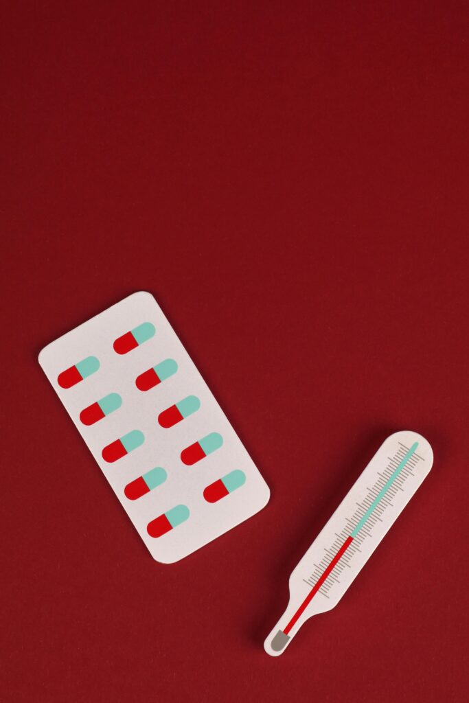 Thermometer and meds are displayed with red background